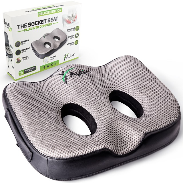 The Aylio Socket Seat cushion at a three-quarter angle, showing its two contoured sit-bone openings and airflow mesh top, beside its retail box.